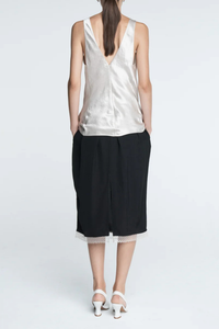 back profile model wearing  Lace Tulip Skirt Black
Elastic waistband
Hidden side pockets
Bouncy, lightweight Japanese Naia twill
Midi length
Slit at back
White lace hem

