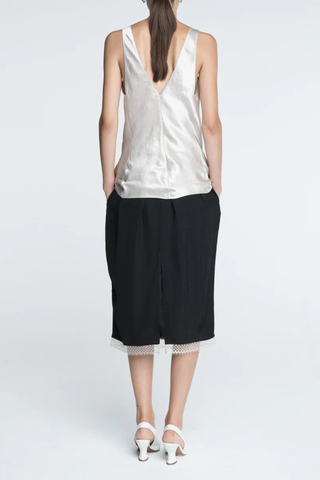 back profile model wearing  Lace Tulip Skirt Black
Elastic waistband
Hidden side pockets
Bouncy, lightweight Japanese Naia twill
Midi length
Slit at back
White lace hem
