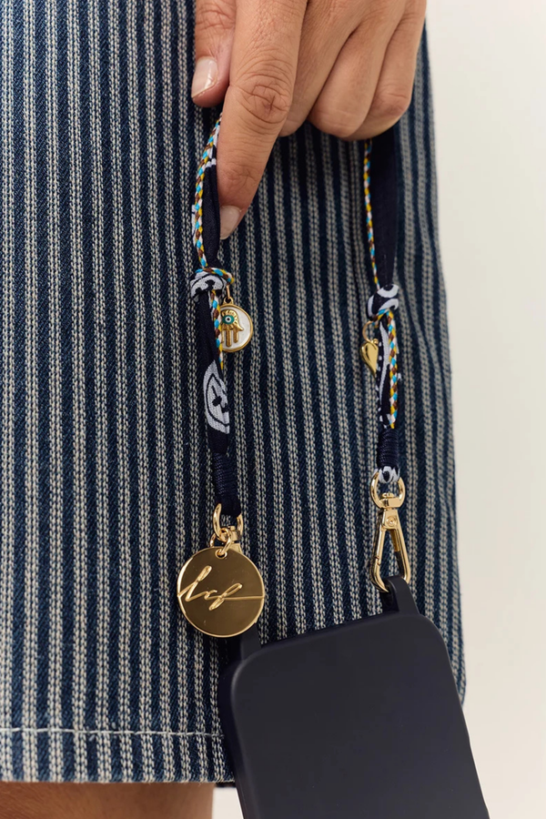 model wearing Laia Short Phone Chain Blue Short phone chain
Chain easily attaches to the rings of La Coque Francaise phone cases. If you don't have a ring case, a universal adapter is available - sold separately.

Composition: cotton voile and charms
Finishes: swivel carabiners and stainless steel rings
Length: 40 cm