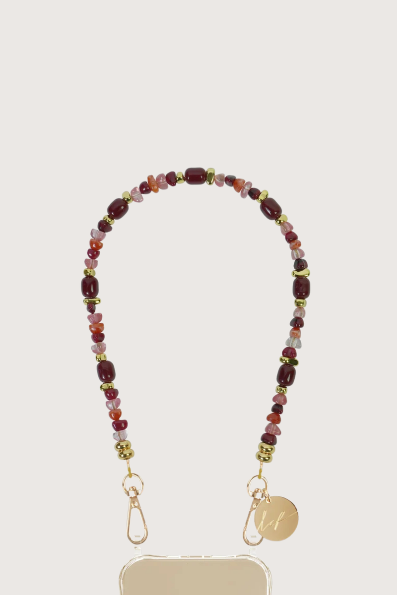 close up flat lay Lana Short Phone Chain Bordeaux Chain easily attaches to the rings on La Coque Francaise phone cases
If you don't have a ring case, a universal adapter is available to use it with any case, sold separately
Composition: burgundy resin and glass beads and gold hematite beads
Finish: gold rotating carabiners and stainless steel rings
Length: 40 cm