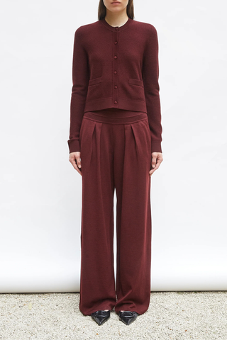 front profile model wearing Lauren Fluid Knit Trouser Amarante red Flowing knit pants Supple jersey knit Wide scalloped waistband Box pleats on the front