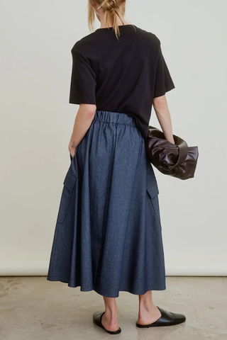 back profile model wearing Le Cargo Full Flared Skirt Dark Denim Oversized cargo pockets
On-seam pockets
Wide elastic waist
Tiny rolled hem
100% Japanese Denim