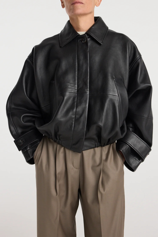front profile model wearing Leather Blouson Jacket black Cropped bomber jacket
Dropped shoulders
Wide sleeves
Sleeve straps
Button closures
Sculptural silhouette
100% leather