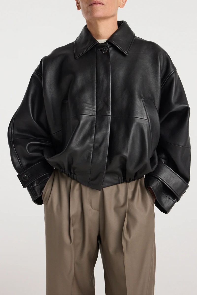 front profile model wearing Leather Blouson Jacket black Cropped bomber jacket
Dropped shoulders
Wide sleeves
Sleeve straps
Button closures
Sculptural silhouette
100% leather