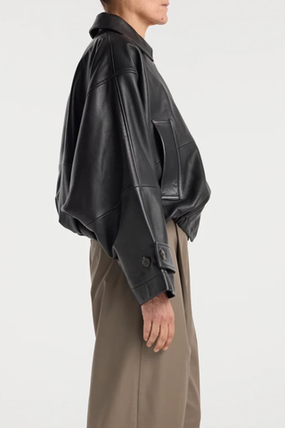 side profile model wearing Leather Blouson Jacket black Cropped bomber jacket
Dropped shoulders
Wide sleeves
Sleeve straps
Button closures
Sculptural silhouette
100% leather