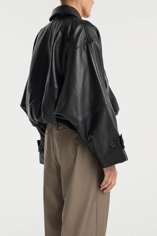 back profile model wearing Leather Blouson Jacket black Cropped bomber jacket
Dropped shoulders
Wide sleeves
Sleeve straps
Button closures
Sculptural silhouette
100% leather