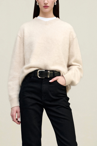 front profile model wearing Lena V-neck Brushed Cashmere Sweater coconut white oversized fit dropped shoulders long sleeve