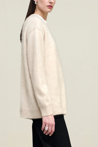 side profile model wearing Lena V-neck Brushed Cashmere Sweater coconut white oversized fit dropped shoulders long sleeve