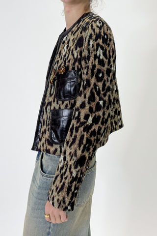side profile model wearing  Leopard Jacket With Leather Trim & Pin brown and olive Collarless
Roundneck
Croc effect collar trim and front pockets
Long sleeve
Boxy cropped fit

Includes pink gemstone pin