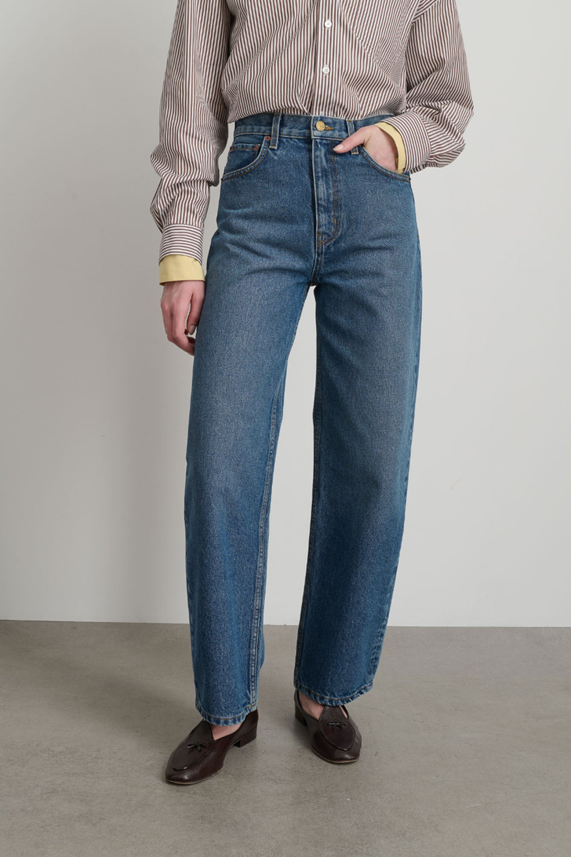 front profile model wearing Leroy Mid Relaxed Jean  blue wash Arched leg shape Mid rise Relaxed fit Barrel-legged silhouette