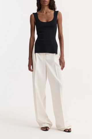 front profile model wearing  Long Knitted Bustier Top black Knitted top
Scoop neckline viscose-blend yarn
Elongated silhouette
Side slit details
Fitted style