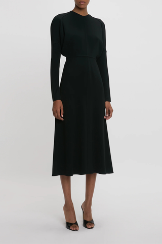 side profile model wearing Long Sleeve Dolman Midi Dress Black Long sleeve
Round neckline
Defined waist
Draped feature at sleeve underarm, fitted sleeve through the forearm
Midi length silhouette
Tonal topstitching
voluminous underarm drape
Fitted at the waist and more relaxed fit through bodice and hip
Concealed zip with hook and eye closure at back
Concealed zip opening at cuff