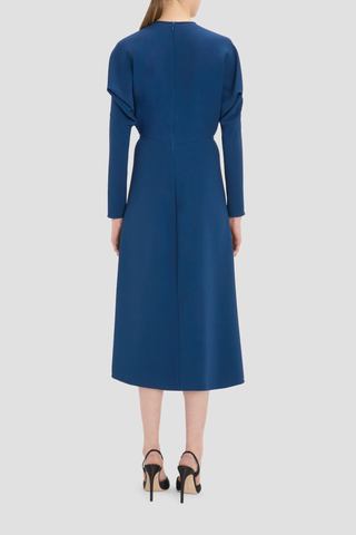 back profile model wearing long Sleeve Dolman Midi Dress Dark Ocean blue Dolman long sleeve
Round neckline
Defined waist
Draped feature at sleeve underarm, fitted sleeve through the forearm
Midi length 
Tonal topstitching
voluminous underarm drape
Fitted at the waist and more relaxed fit through bodice and hip