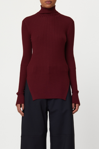 front profile model wearing Long Sleeve Merino wool T-Neck sweater burgundy, Fitted ribbed turtle neck sweater, High side slit