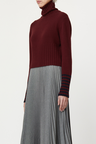 side profile model wearing Long Sleeve T-neck Button Back Sweater burgundy wool, Turtleneck, Button back detail, Covered buttons, Horizontal stripe detail on cuff, Thick ribbed hem and cuff, Shrunken cropped fit