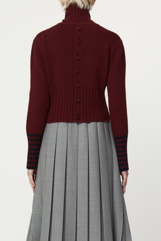 back profile model wearing Long Sleeve T-neck Button Back Sweater burgundy wool, Turtleneck, Button back detail, Covered buttons, Horizontal stripe detail on cuff, Thick ribbed hem and cuff, Shrunken cropped fit