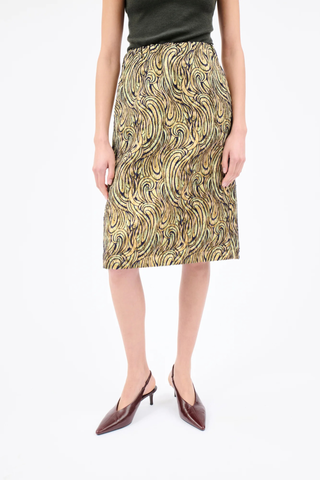front profile model wearing  Lurex Paisley Wave Pencil Skirt greengold Knee-length skirt
Straight cut
Sewn-in elastic waistband
Side-seam pockets
High slit at the back
Center-back zipper with ribbon pull
Material: 73% polyester, 27% polyamide