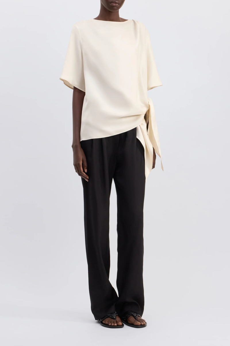 front profile model wearing Mano Short Sleeve Knotted Blouse Ivory Straight fit
Short sleeves
Boat neck
Gathered fabric at the shoulders
Asymmetric hemline
Knotted waist detail
100% Silk Twill