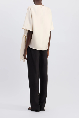 back profile model wearing Mano Short Sleeve Knotted Blouse Ivory Straight fit
Short sleeves
Boat neck
Gathered fabric at the shoulders
Asymmetric hemline
Knotted waist detail
100% Silk Twill