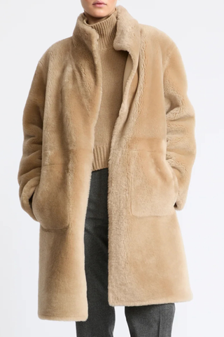 front profile model wearing untied Manteau Reversible Jacket Pampas beige Midi length coat
Two faces of a Merino lambskin shearling
Reversible, it can be worn with the skin side or the wool side facing out
High collar
Matching belt
Welt pockets
Unlined
100% Lamb