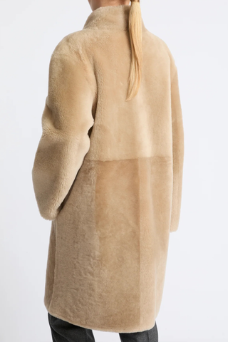back profile model wearing Manteau Reversible Jacket Pampas beige Midi length coat
Two faces of a Merino lambskin shearling
Reversible, it can be worn with the skin side or the wool side facing out
High collar
Matching belt
Welt pockets
Unlined
100% Lamb