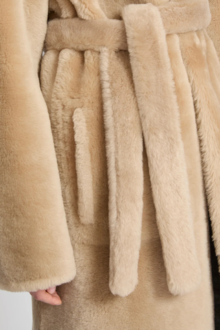 close up fur texture detail for Manteau Reversible Jacket Pampas beige Midi length coat
Two faces of a Merino lambskin shearling
Reversible, it can be worn with the skin side or the wool side facing out
High collar
Matching belt
Welt pockets
Unlined
100% Lamb