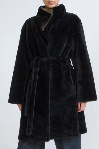 front profile model wearing Manteau Reversible Jacket Storm black fur side Midi length coat
Two faces of a Merino lambskin shearling
Reversible, it can be worn with the skin side or the wool side facing out
High collar
Matching belt
Welt pockets
Unlined
100% Lamb