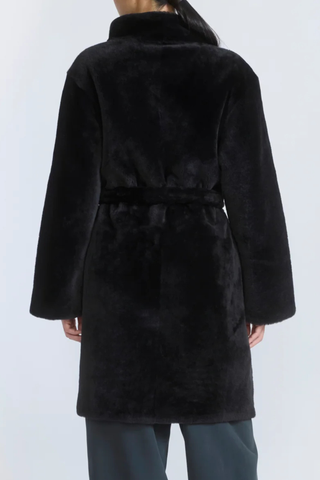 back profile model wearing Manteau Reversible Jacket Storm black fur side Midi length coat
Two faces of a Merino lambskin shearling
Reversible, it can be worn with the skin side or the wool side facing out
High collar
Matching belt
Welt pockets
Unlined
100% Lamb