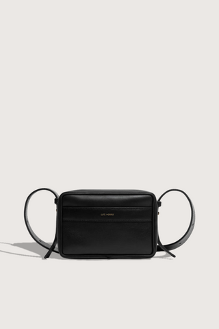 flat lay Maya cooper black Bag smooth leather exterior back pocket adjustable strap structured square shape