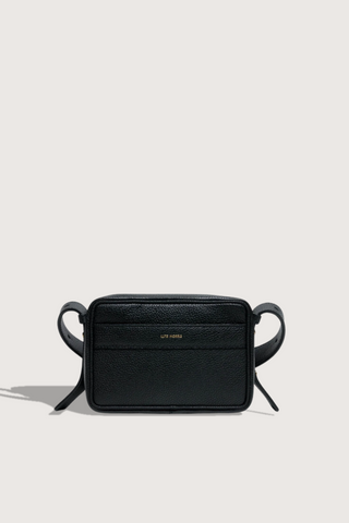 flat lay Maya Brandon Black Bag pebbled leather exterior back pocket adjustable strap structured square shape