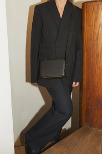 model wearing Maya Brandon Black Bag pebbled leather exterior back pocket adjustable strap structured square shape