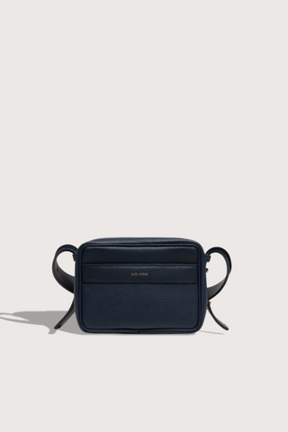 flat lay Maya Brandon Navy Bag pebbled leather exterior back pocket adjustable strap structured square shape