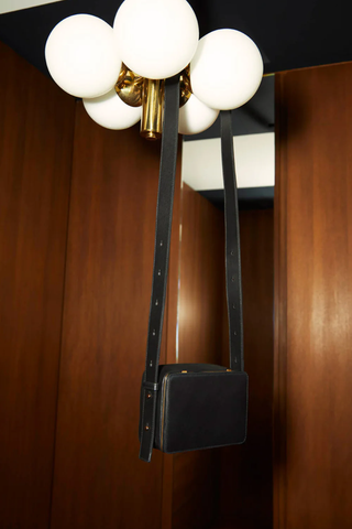 editorial photo of Maya cooper black Bag smooth leather exterior back pocket adjustable strap structured square shape