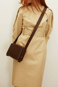 model wearing Maya cooper chocolate Bag smooth leather exterior back pocket adjustable strap structured square shape