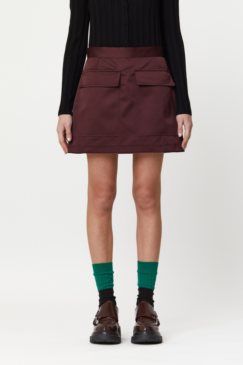 front profile model wearing Mini Skirt With Pockets, Burgundy mini skirt, Duchesse satin, Hip flap pockets, Concealed back zipper closure