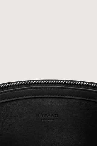 close detail of inside logo and zipper for Moore Cross Body Bag Ink black Folded leather panel construction
Top zip closure
Two separate interior compartments
Adjustable strap is fixed on the interior
100% Calfskin Leather