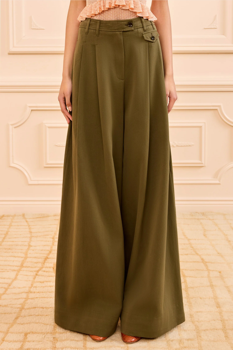 front profile model wearing Motherwell Trouser pinon green 
 pleated
Front coin-flap pocket
Italian cotton twill
Mid-rise, wide leg
Side and back pockets
Concealed front hook, button, and zipper