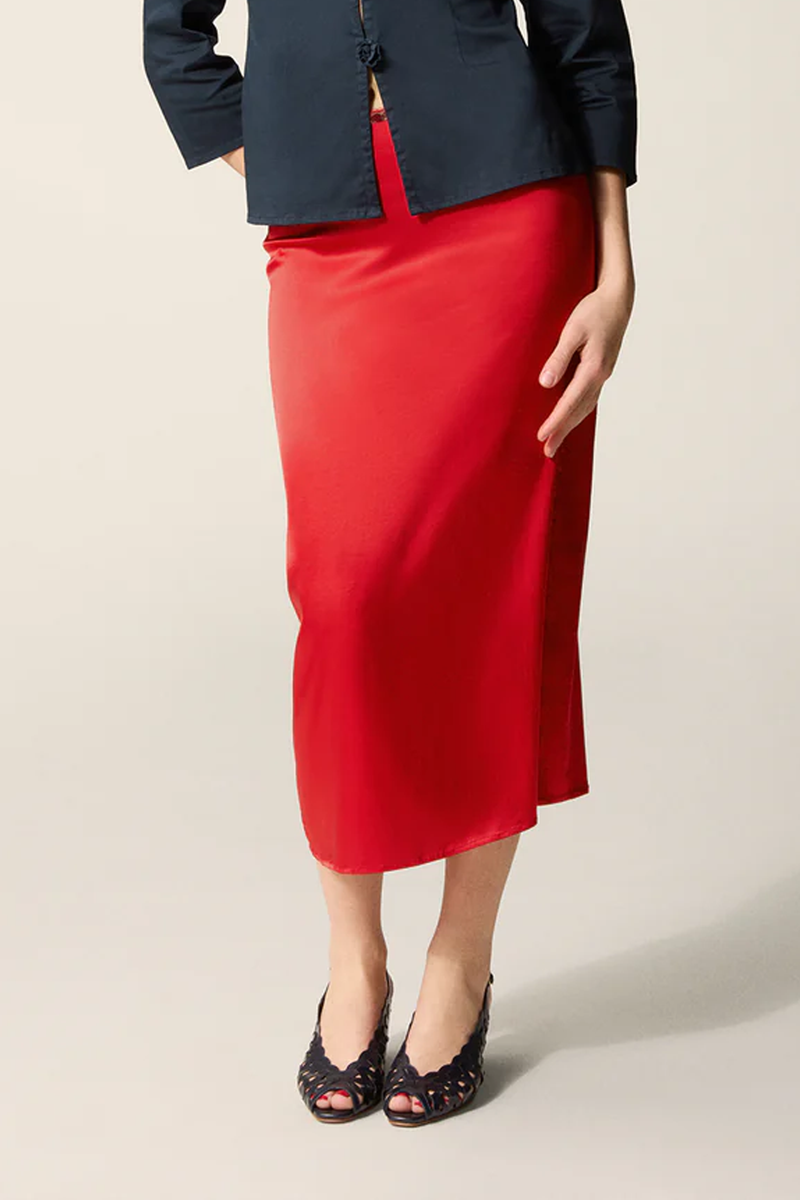 front profile model wearing Naella Satin Skirt red