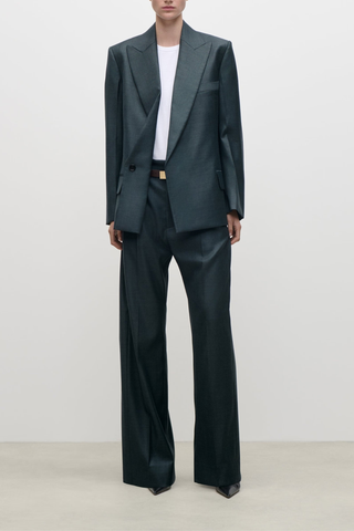 front profile model wearing Olie Sculptural Layerd Classic Wool Jacket marsh green Tailored jacket
Dark grey-blue tone
Structured silhouette
Fluid wool tailoring
Fold back front lapel
Layered jacket with patch pockets
Fully lined and concealed front fastening
100% Virgin Wool