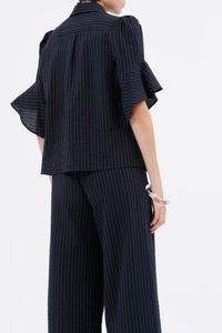 back profile model wearing Organza Stripe Short Sleeve Top ink blue cotton Vertical stripe
Concealed button placket
Classic collar
Short sleeves
Ruffle at the hem