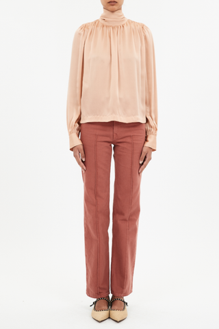 front profile model wearing  Ornament Tie Neck Blouse sand color silk Billowing top
Ties that fasten at the front or the back high neck