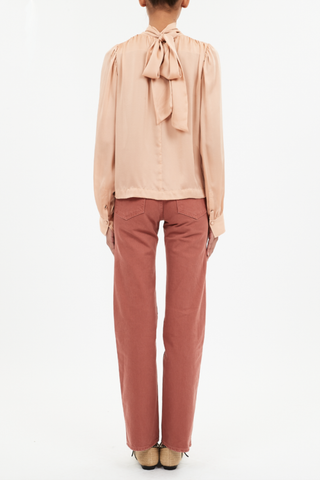 back profile model wearing  Ornament Tie Neck Blouse sand color silk Billowing top
Ties that fasten at the front or the back high neck