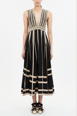 front profile model wearing Palermo Deep V Midi Dress Ric-rac and grosgrain ribbons
Black silhouette
Plunging neckline
Full, gathered hem
Water-washed cotton poplin
Midi length
Sleeveless