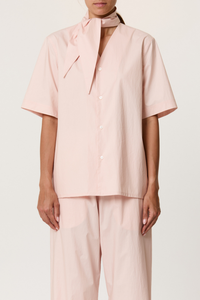 front profile model wearing Parachute Short Sleeve With Tie baby pink cotton Short sleeve cotton shirt
V-neck collar with detachable shawl
Front buttons closure
The cut is straight