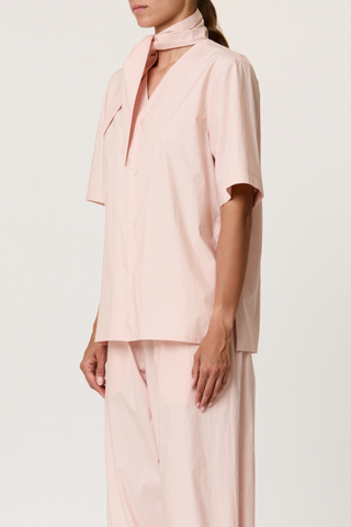 side profile model wearing Parachute Short Sleeve With Tie baby pink cotton Short sleeve cotton shirt
V-neck collar with detachable shawl
Front buttons closure
The cut is straight