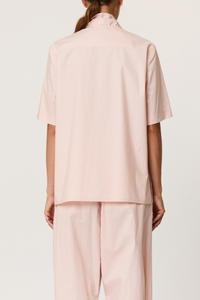 back profile model wearing Parachute Short Sleeve With Tie baby pink cotton Short sleeve cotton shirt
V-neck collar with detachable shawl
Front buttons closure
The cut is straight