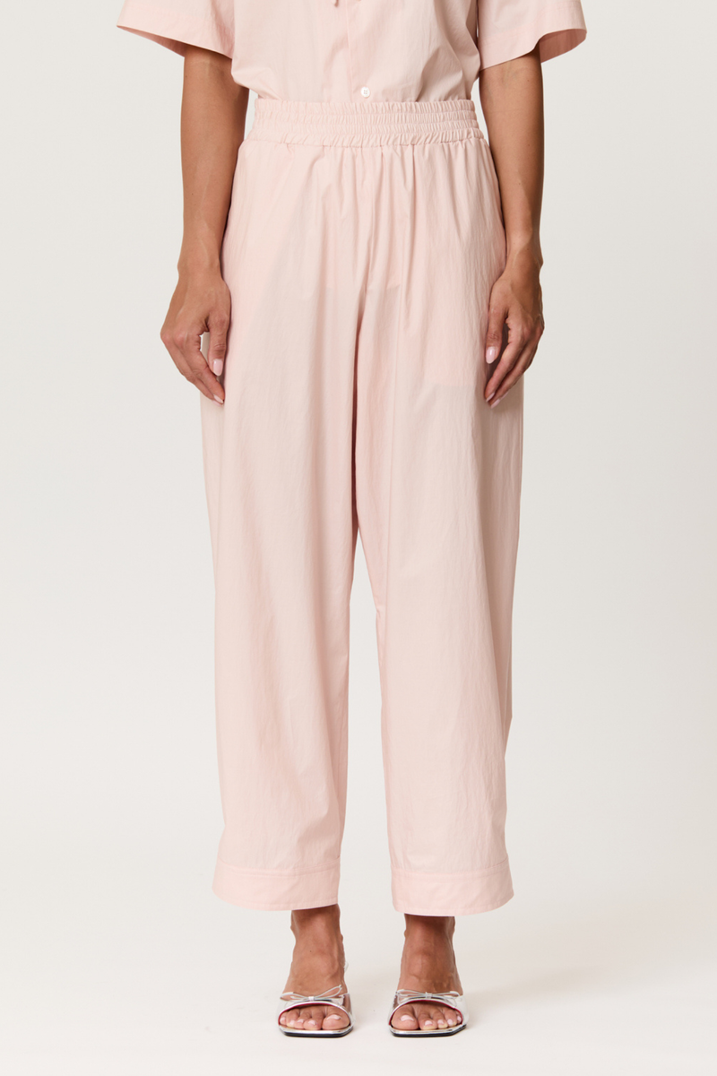 front profile model wearing Parachute Trouser With Side Detail baby pink cotton Light pink technical trousers
Smocked elastic waistband
Relaxed, tapered silhouette