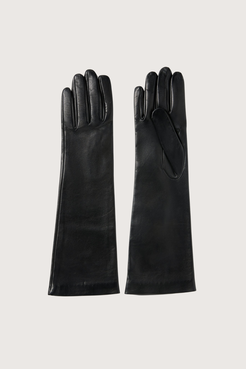 flat lay Park Leather Gloves Black Mid-length gloves
Supple leather
Three point stitches at the back of the hand
Clean finished cuff
Cut to extend past the wrist for coverage under outerwear
Handmade with light silk jersey lining
