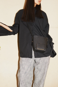 model wearing Parker S Soft Black leather Crossbody Bag with adjustable strap and exterior pocket