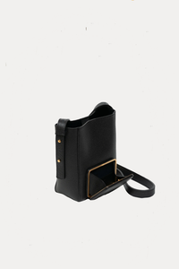 side profile of Parker S Soft Black leather Crossbody Bag with adjustable strap and exterior pocket with open pocket